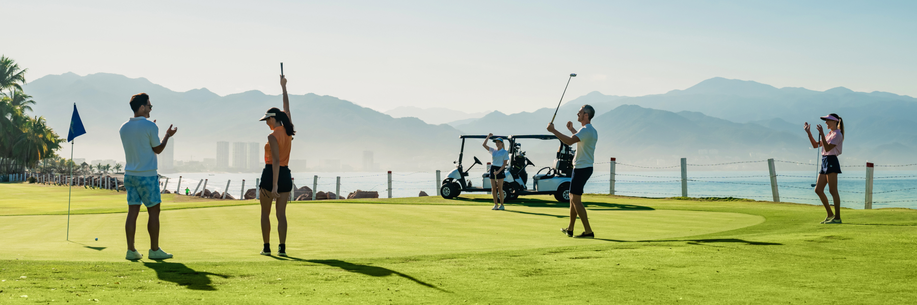 Golfers playing on green field in background at Grand Velas