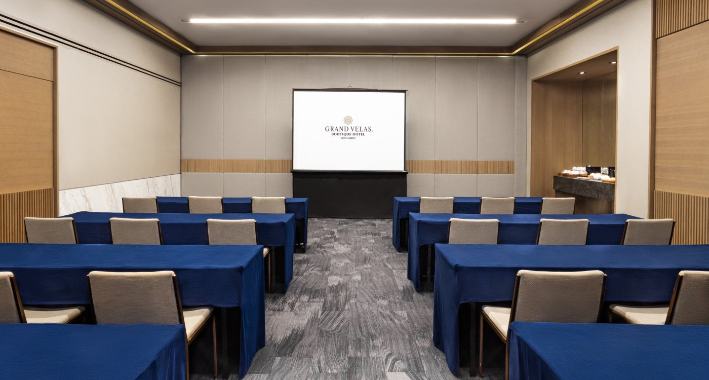 Grand Velas Boutique Hotel Los Cabos conference room with blue tables and chairs.